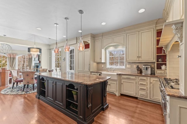 1031 Steamboat Blvd, Steamboat Springs, CO 80487 - kitchen featuring open shelves, cream cabinetry, wood finished floors, pendant lighting, and light stone countertops
