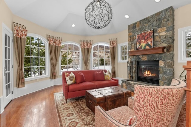 1031 Steamboat Blvd, Steamboat Springs, CO 80487 - living room featuring vaulted ceiling, plenty of natural light, wood finished floors, and a stone fireplace