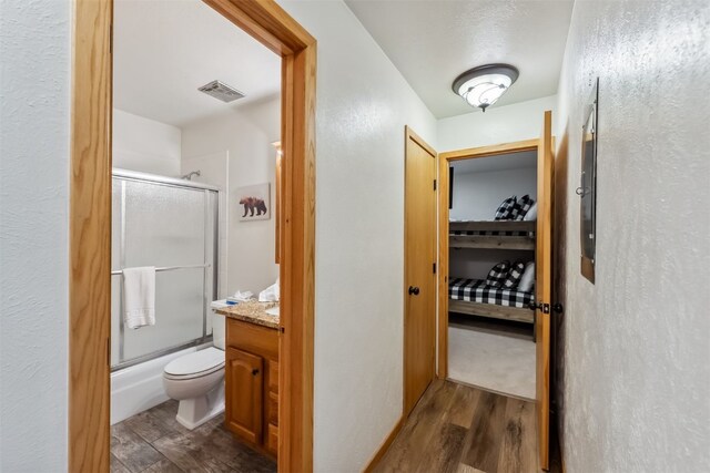 119 Royal Tiger Rd, Breckenridge, CO 80424 - full bath with wood finished floors, toilet, shower / bath combination with glass door, and vanity