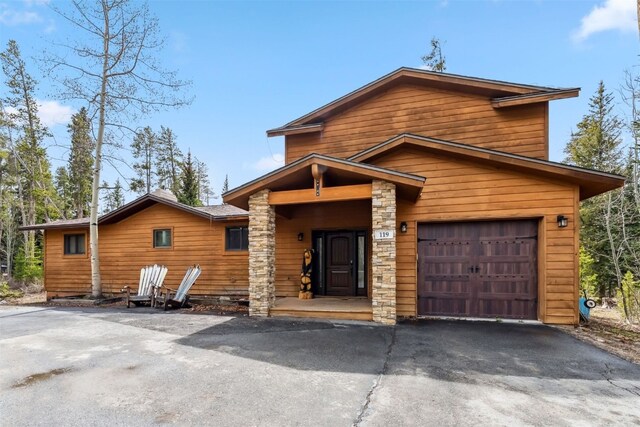 119 Royal Tiger Rd, Breckenridge, CO 80424 - view of front facade with asphalt driveway, stone siding, and an attached garage