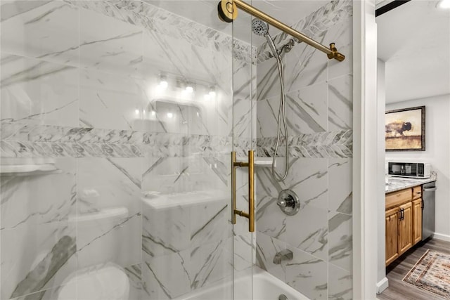 full bath with vanity, wood finished floors, and bath / shower combo with glass door