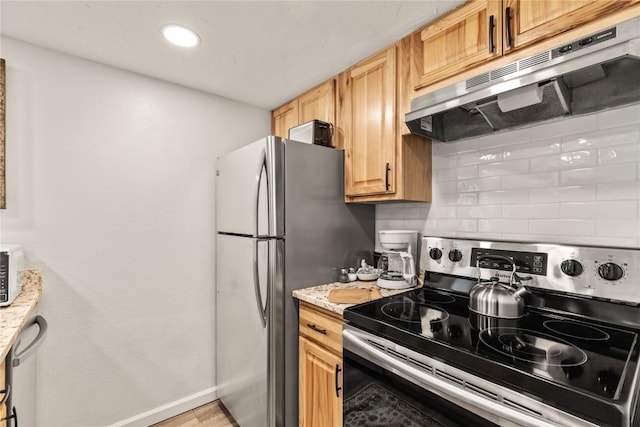 kitchen featuring recessed lighting, under cabinet range hood, stainless steel appliances, baseboards, and tasteful backsplash
