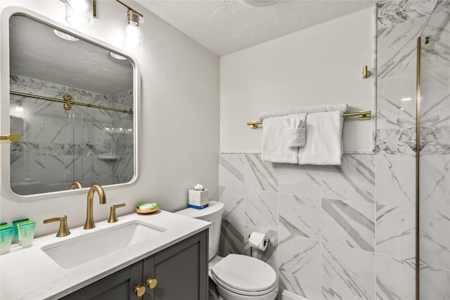 full bath with toilet, vanity, and a marble finish shower