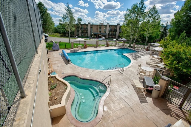 pool with fence and a patio
