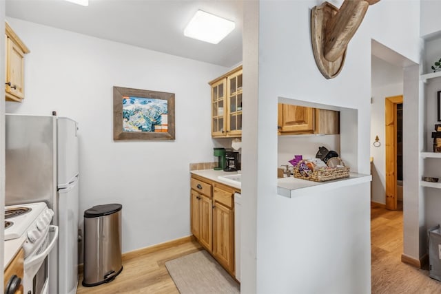 1937 Soda Ridge Rd Unit 1146, Keystone, CO 80435 - kitchen with light countertops, light wood-type flooring, white range oven, and glass insert cabinets