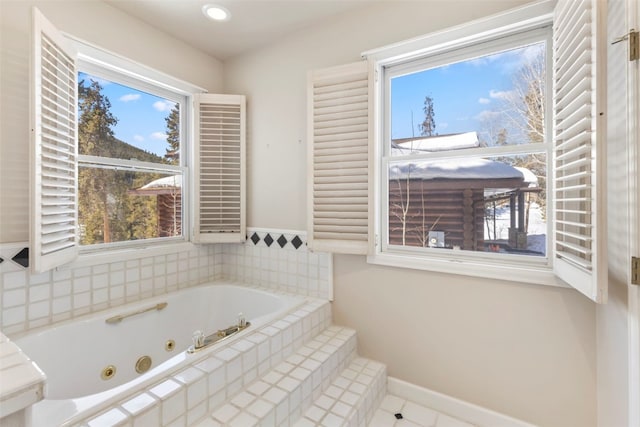 bathroom with a jetted tub and baseboards