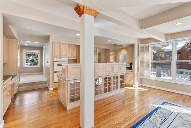 interior space featuring light wood-type flooring, baseboards, and light brown cabinetry