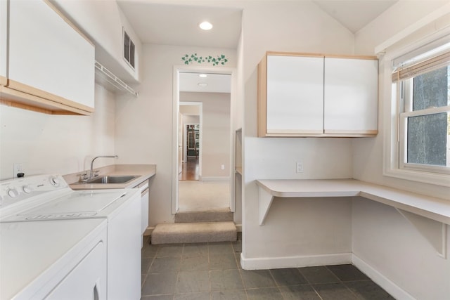 clothes washing area featuring a sink, visible vents, baseboards, washer and dryer, and cabinet space