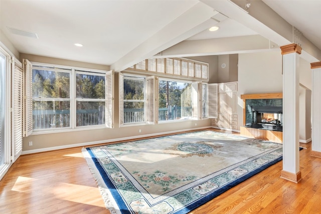 living area with beam ceiling, recessed lighting, a high end fireplace, wood finished floors, and baseboards