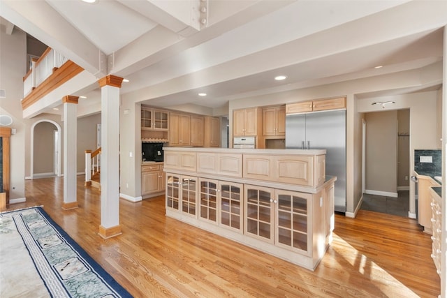 kitchen featuring glass insert cabinets, recessed lighting, light brown cabinets, and light wood finished floors