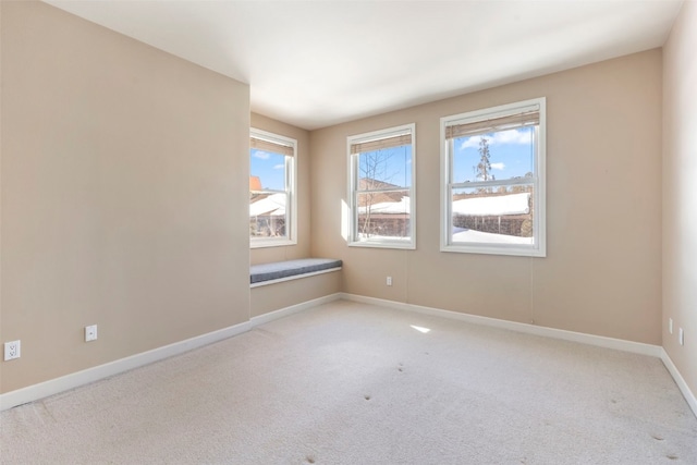 carpeted empty room featuring baseboards