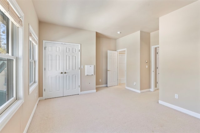 unfurnished bedroom with a closet, carpet, and baseboards