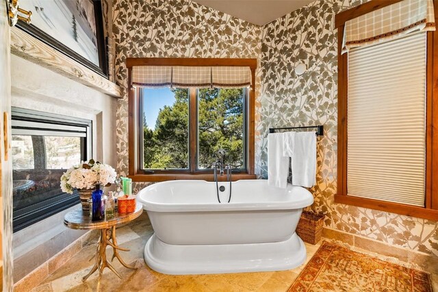 197 Wild Irishman Rd, Keystone, CO 80435 - bathroom featuring wallpapered walls, a glass covered fireplace, and a freestanding bath