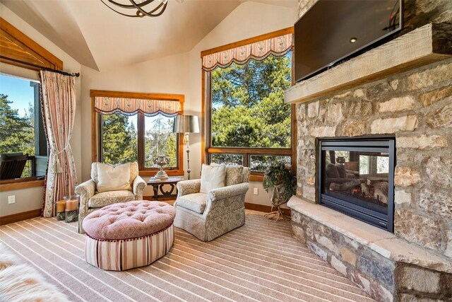 197 Wild Irishman Rd, Keystone, CO 80435 - living area featuring vaulted ceiling, baseboards, a stone fireplace, and carpet flooring
