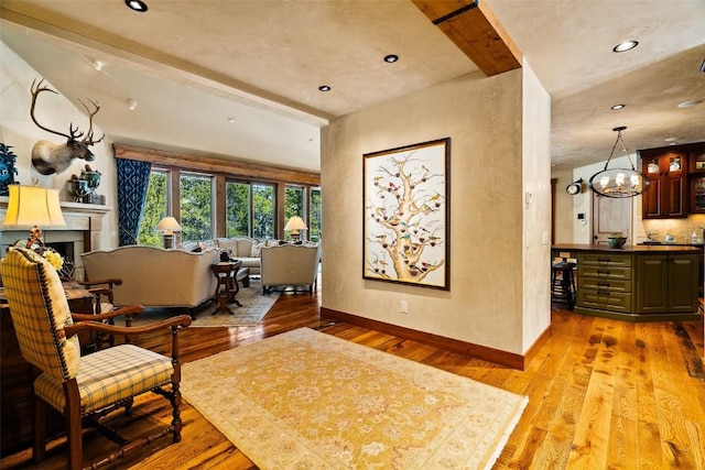 197 Wild Irishman Rd, Keystone, CO 80435 - sitting room with light wood-type flooring, a chandelier, a fireplace, baseboards, and recessed lighting