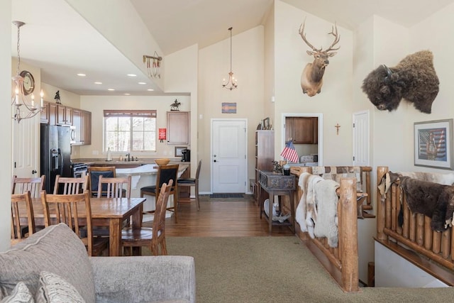 living area featuring recessed lighting, dark wood-style flooring, high vaulted ceiling, and a notable chandelier