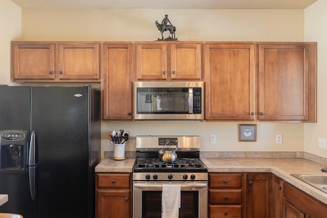 kitchen with brown cabinets, appliances with stainless steel finishes, and a sink