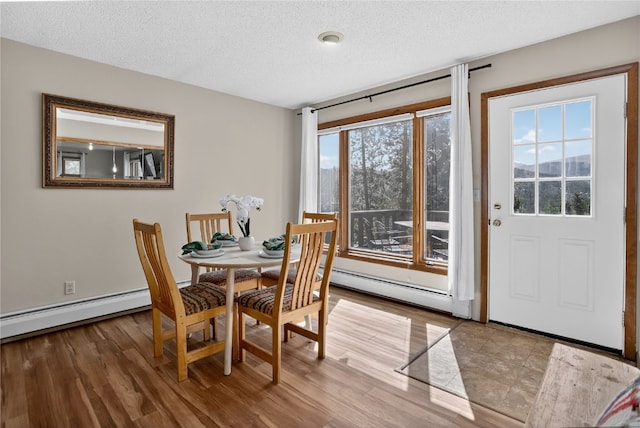 24 Ski Pole Ct, Breckenridge, CO 80424 - dining area featuring a baseboard radiator, a textured ceiling, and wood finished floors