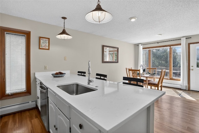 24 Ski Pole Ct, Breckenridge, CO 80424 - kitchen featuring baseboard heating, a textured ceiling, a peninsula, dishwasher, and wood finished floors