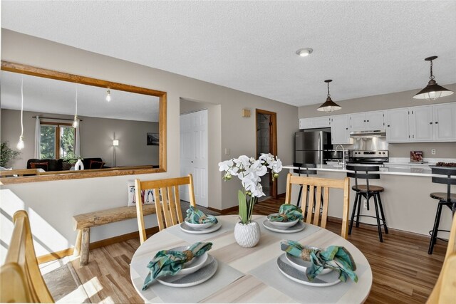 24 Ski Pole Ct, Breckenridge, CO 80424 - dining area featuring light wood-style floors and a textured ceiling