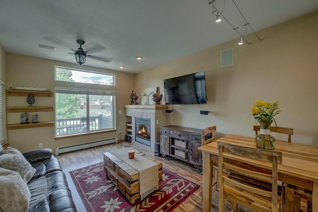 102 Creek Ln Unit 102, Silverthorne, CO 80498 - living area featuring baseboard heating, ceiling fan, wood finished floors, and a tiled fireplace