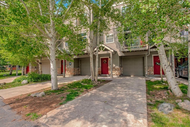 102 Creek Ln Unit 102, Silverthorne, CO 80498 - view of property with a garage, stone siding, driveway, and a balcony