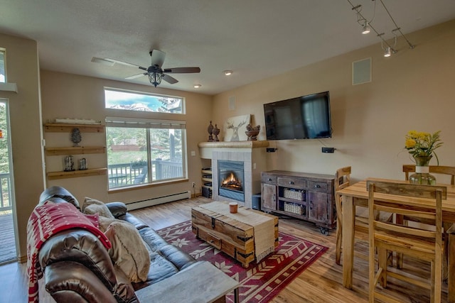 102 Creek Ln Unit 102, Silverthorne, CO 80498 - living area featuring baseboard heating, ceiling fan, wood finished floors, and a tile fireplace