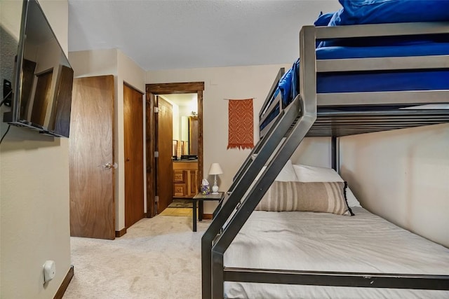 bedroom featuring ensuite bathroom and carpet