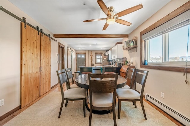 dining room featuring a baseboard radiator, a barn door, a ceiling fan, beamed ceiling, and baseboards