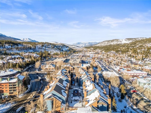 snowy aerial view with a mountain view and a residential view