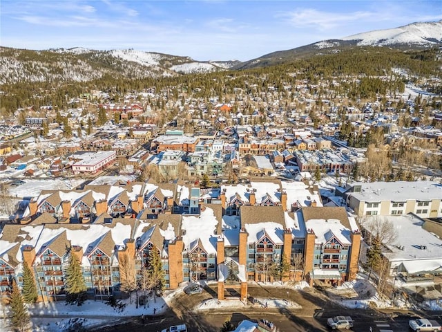 snowy aerial view featuring a mountain view and a residential view