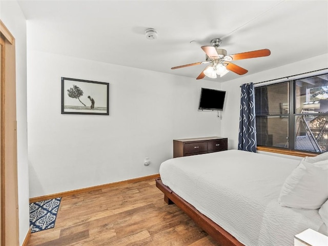 bedroom featuring ceiling fan, baseboards, and wood finished floors