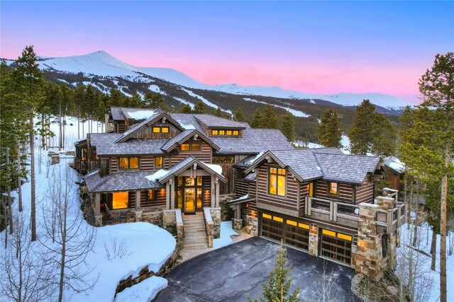 422 Timber Trail Rd, Breckenridge, CO 80424 - view of front facade featuring an attached garage, aphalt driveway, a mountain view, and stone siding