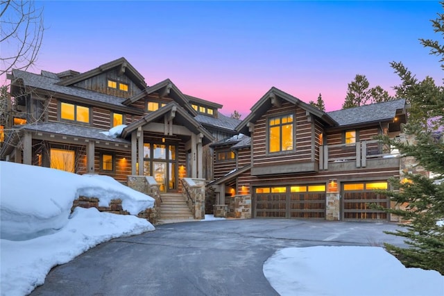 422 Timber Trail Rd, Breckenridge, CO 80424 - log home with an attached garage, aphalt driveway, and stone siding
