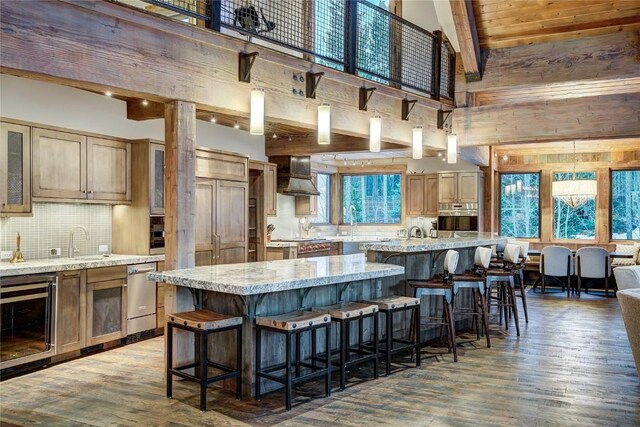 422 Timber Trail Rd, Breckenridge, CO 80424 - kitchen with tasteful backsplash, light wood finished floors, wine cooler, stainless steel appliances, and wall chimney exhaust hood