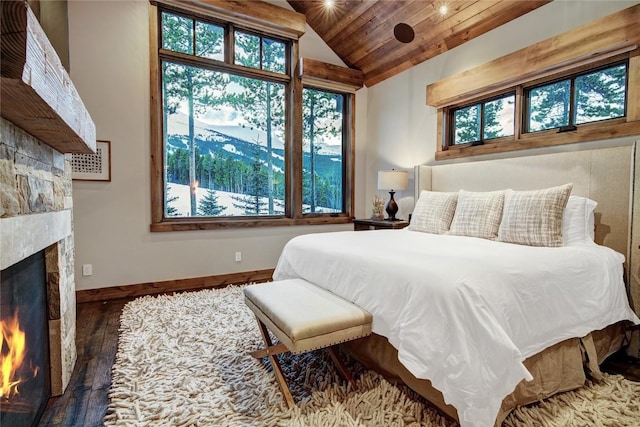 422 Timber Trail Rd, Breckenridge, CO 80424 - bedroom with wood finished floors, lofted ceiling, baseboards, a lit fireplace, and wooden ceiling
