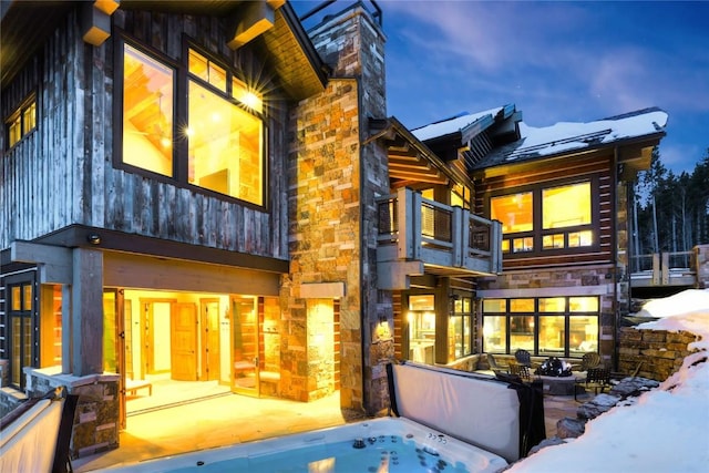 422 Timber Trail Rd, Breckenridge, CO 80424 - back of house featuring board and batten siding, stone siding, a chimney, and a balcony