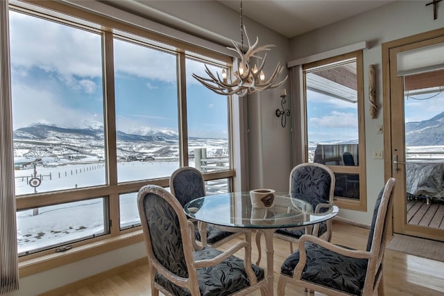 1235 Elk Run Rd, Silverthorne, CO 80498 - dining area with a chandelier, a mountain view, light wood-style floors, and baseboards