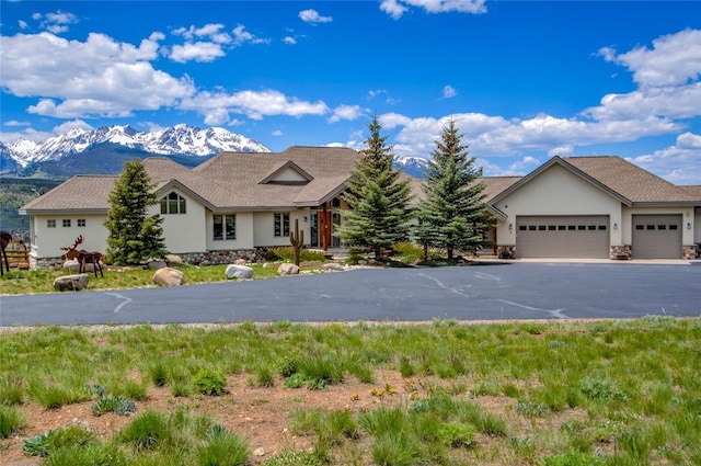 1235 Elk Run Rd, Silverthorne, CO 80498 - ranch-style home featuring asphalt driveway, a mountain view, stucco siding, a garage, and stone siding