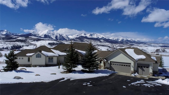 1235 Elk Run Rd, Silverthorne, CO 80498 - view of front of property featuring a garage, a mountain view, and stucco siding