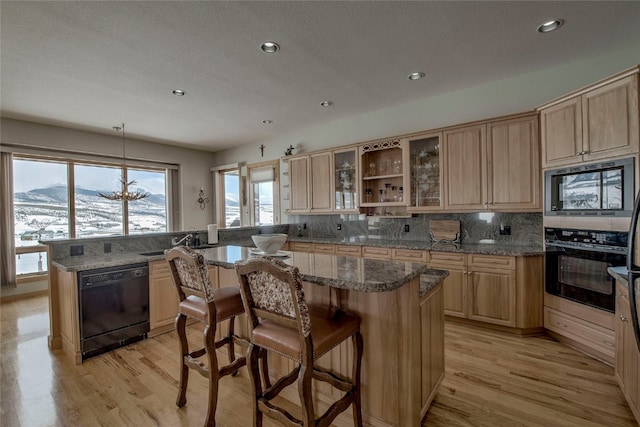 1235 Elk Run Rd, Silverthorne, CO 80498 - kitchen featuring black appliances, light brown cabinetry, a kitchen breakfast bar, recessed lighting, and a textured ceiling