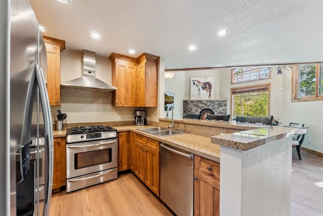 24 Rasor Dr Unit 24, Keystone, CO 80435 - kitchen featuring appliances with stainless steel finishes, wall chimney range hood, a peninsula, light wood-type flooring, and recessed lighting