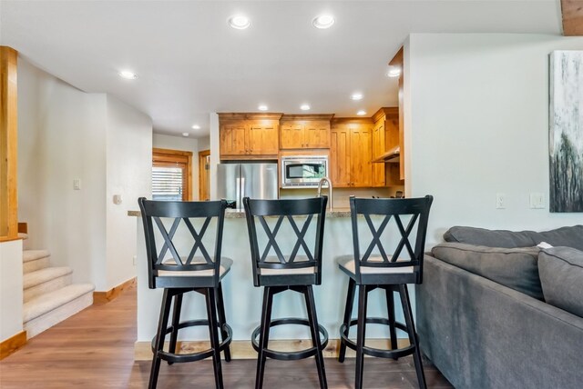 24 Rasor Dr Unit 24, Keystone, CO 80435 - kitchen with appliances with stainless steel finishes, a breakfast bar, open floor plan, a peninsula, and recessed lighting