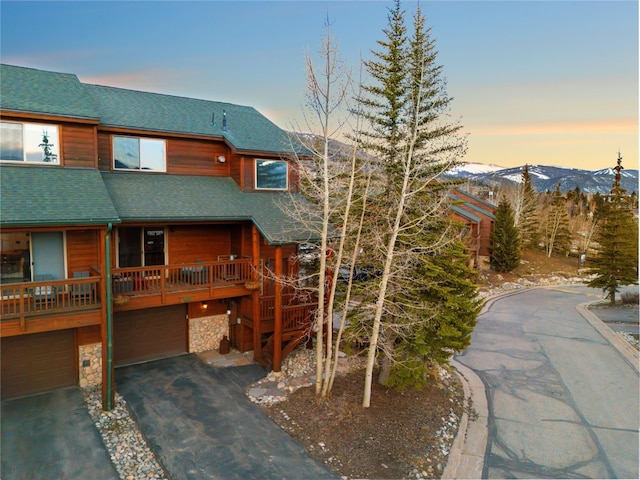 60 Lookout Ridge Dr, Dillon, CO 80435 - chalet / cabin featuring aphalt driveway, stone siding, roof with shingles, an attached garage, and a mountain view