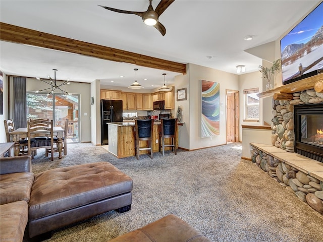 60 Lookout Ridge Dr, Dillon, CO 80435 - living room featuring light colored carpet, a fireplace, beam ceiling, baseboards, and ceiling fan with notable chandelier