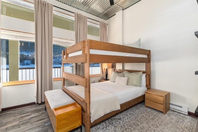 22174 US Highway 6 Unit 7, Keystone, CO 80435 - bedroom with a baseboard radiator, wood finished floors, and multiple windows