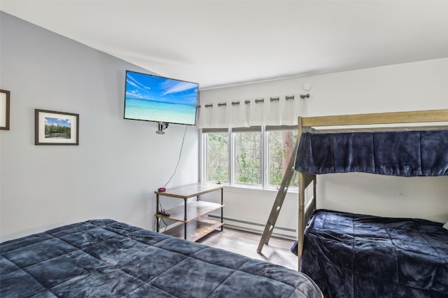 bedroom featuring wood finished floors and baseboard heating
