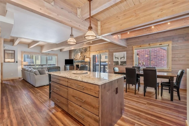 2650 Medicine Springs Dr Unit 11, Steamboat Springs, CO 80487 - kitchen featuring hardwood / wood-style flooring, open floor plan, beamed ceiling, wood walls, and a kitchen island