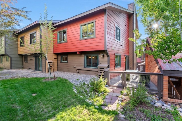 2650 Medicine Springs Dr Unit 11, Steamboat Springs, CO 80487 - rear view of property featuring a chimney and a yard