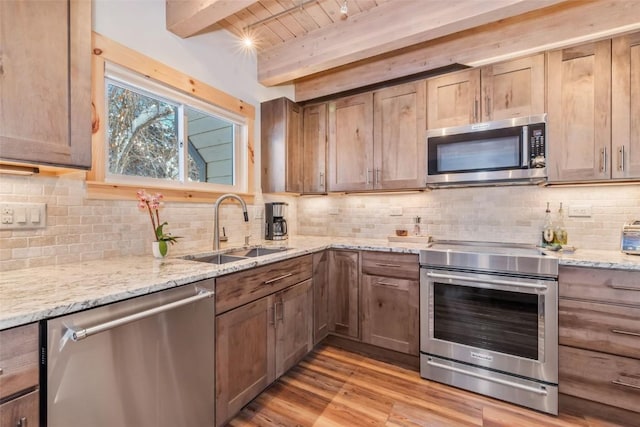 2650 Medicine Springs Dr Unit 11, Steamboat Springs, CO 80487 - kitchen with appliances with stainless steel finishes, a sink, light wood-style flooring, wooden ceiling with exposed beams, and backsplash